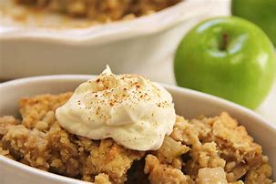 Apple crisp in small white dish topped with delicious crumbs and vanilla icecream. Image from missbuttercup.com